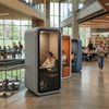 Modern felt-exterior acoustic study pods with glass doors, featuring students working quietly amidst a lively library environment