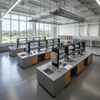 Modern modular central island benches with black epoxy countertops and open storage in an active university research lab