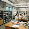 Modular reagent storage steel cabinet with glass panels near island lab benches