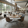 Commercial wood-finish circular discussion tables configured in a modern university library open study zone for collaborative student learning