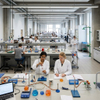 Spacious laboratory island bench with reagent shelving and safety fixtures used in university science laboratories