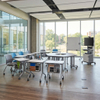 Wide view of an open-plan academic innovation hub with multiple mobile student workstations, collaborative team tables, and flexible seating areas.