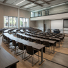 Ergonomic college classroom desks and chairs arranged in a tiered university amphitheater auditorium