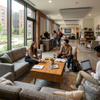 Modern rectangular college dorm coffee table in bright student housing lobby with couch seating