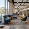 Curved modular library lounge seating with power outlets, yellow chairs, and small wooden tables.
