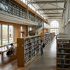Spacious library storage system utilizing open-concept bookcases and study tables in a higher education facility