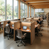 Interior view of a contemporary university library with high wooden ceilings, showcasing multiple wood and felt privacy study tables. Students are seated in ergonomic chairs, studying with laptops and books, with a campus view through floor-to-ceiling windows.