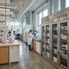 Modern stainless steel vented reagent cabinets with glass doors in a university research laboratory