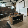 Mobile Instructor Station and Teacher Desk setup on a wooden stage in a minimalist, bright higher education classroom