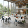 Round collaborative circular discussion tables with wood grain top arranged for group study inside an academic campus building