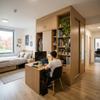 Space-saving student housing wardrobe with built-in bookshelves and storage compartments in college bedroom