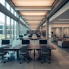 An empty, contemporary library IT lab or computer classroom, showing rows of individual wooden desks with desktop computers, gray ergonomic chairs, and large floor-to-ceiling windows with a view of a building exterior.